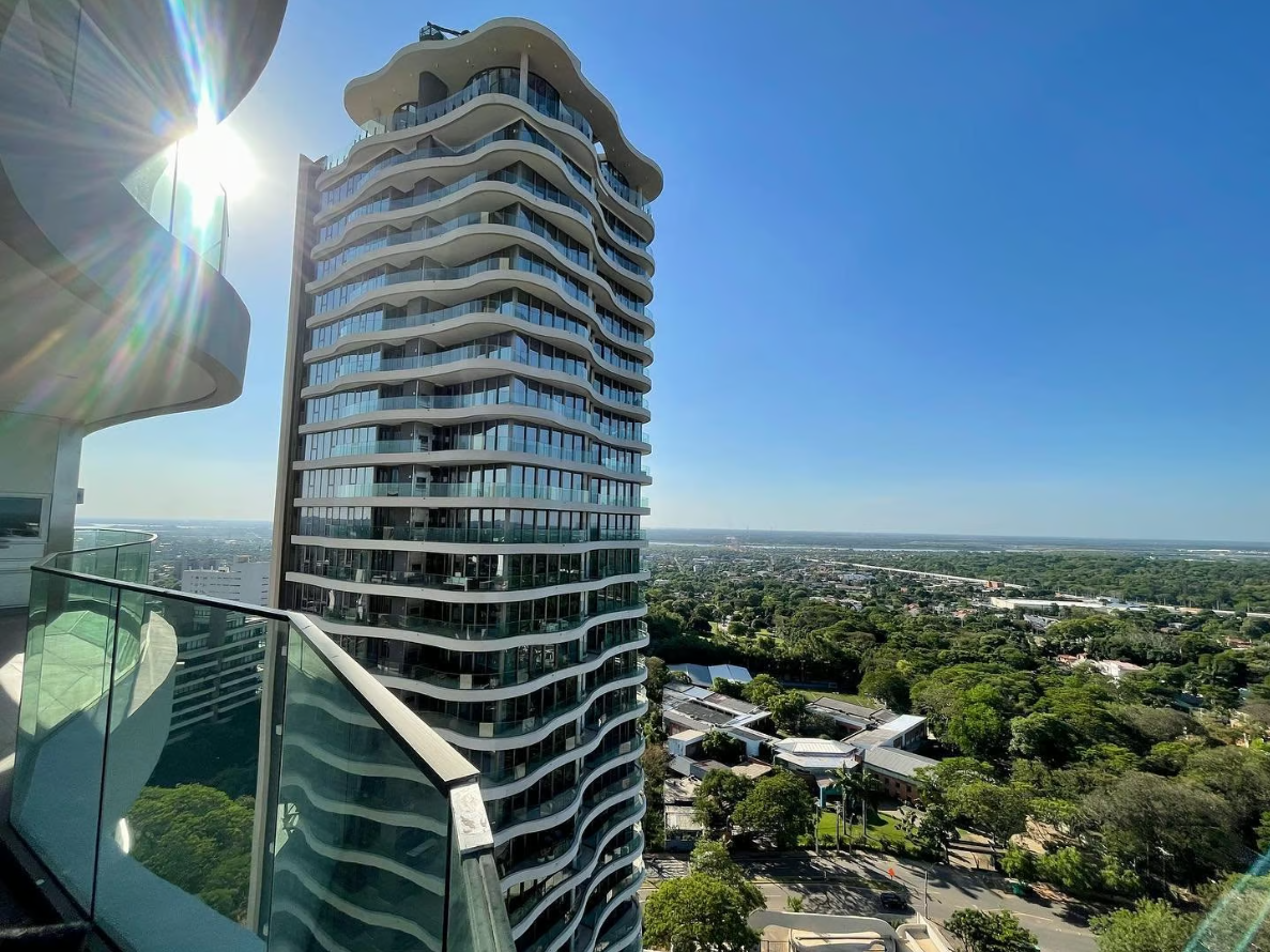 “¿Cómo vivir una vida sin impuestos en Paraguay? Eh, la estructura fiscal más genérica y común que usan mucho los nómades digitales y todas aquellas personas que pueden decirle a su empleador o cliente: "A partir de ahora no me pagás más acá, sino que me pagás en Paraguay", es tener una LLC como no residente, como no ciudadano americano ni residente americano, y tener el RUC personal en Paraguay. Ahí es donde aprovechás la territorialidad, porque uno puede proveer servicios, facturar sin IVA y posteriormente tener una declaración jurada de ganancias sin pagar ganancias. Uno puede declarar todos sus ingresos y tener impuestos cero, porque no es solo no pagar impuestos, sino tener en algún lugar declarada esa renta para que después se pueda utilizar para inversiones, para explicar de dónde viene el dinero. Entonces, esta es una de las estructuras más comunes a la hora de invertir en el real estate, que tiene que ver con una estructura LLC, no necesariamente en Estados Unidos: puede ser en Hong Kong, puede ser en Nevis, puede ser en The Isle of Man; pueden ser en todas estas islas fiscalmente amistosas como no residente y después atarlas a un RUC personal de Paraguay, donde vas a tener una jurisdicción fiscal y todos esos ingresos declarados sin impuesto.”